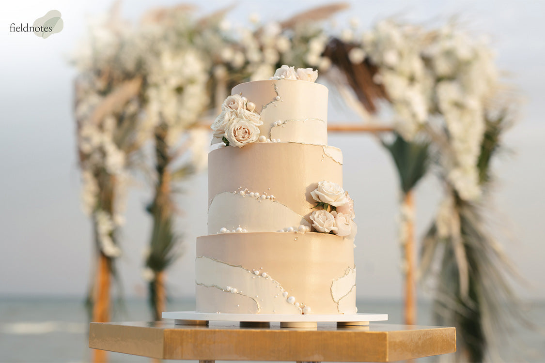 Wedding cake at beach with a Arch Bacground