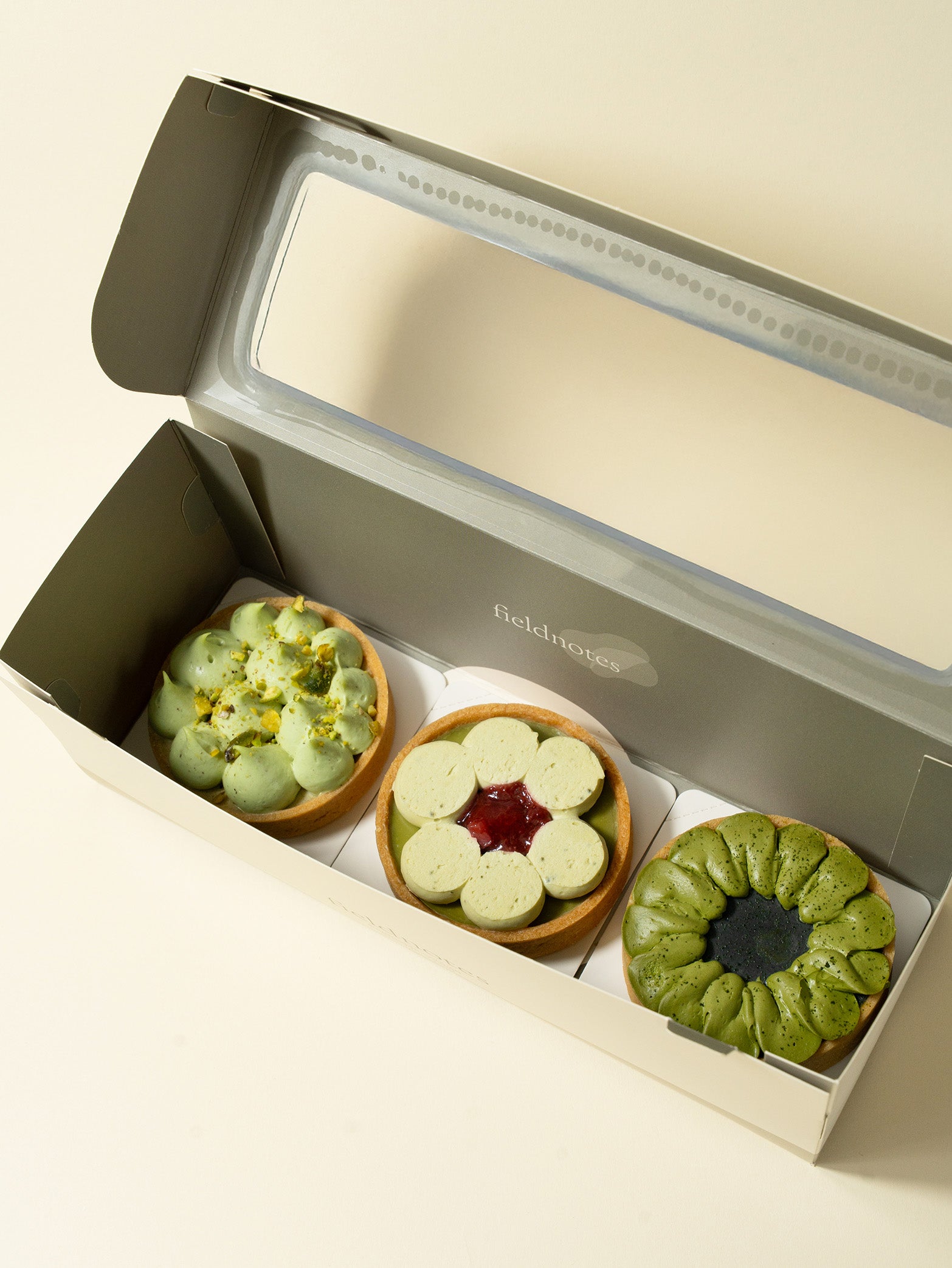 A box of assorted tarts with pistachio, strawberry, and matcha flavors, for tarts order online in Singapore