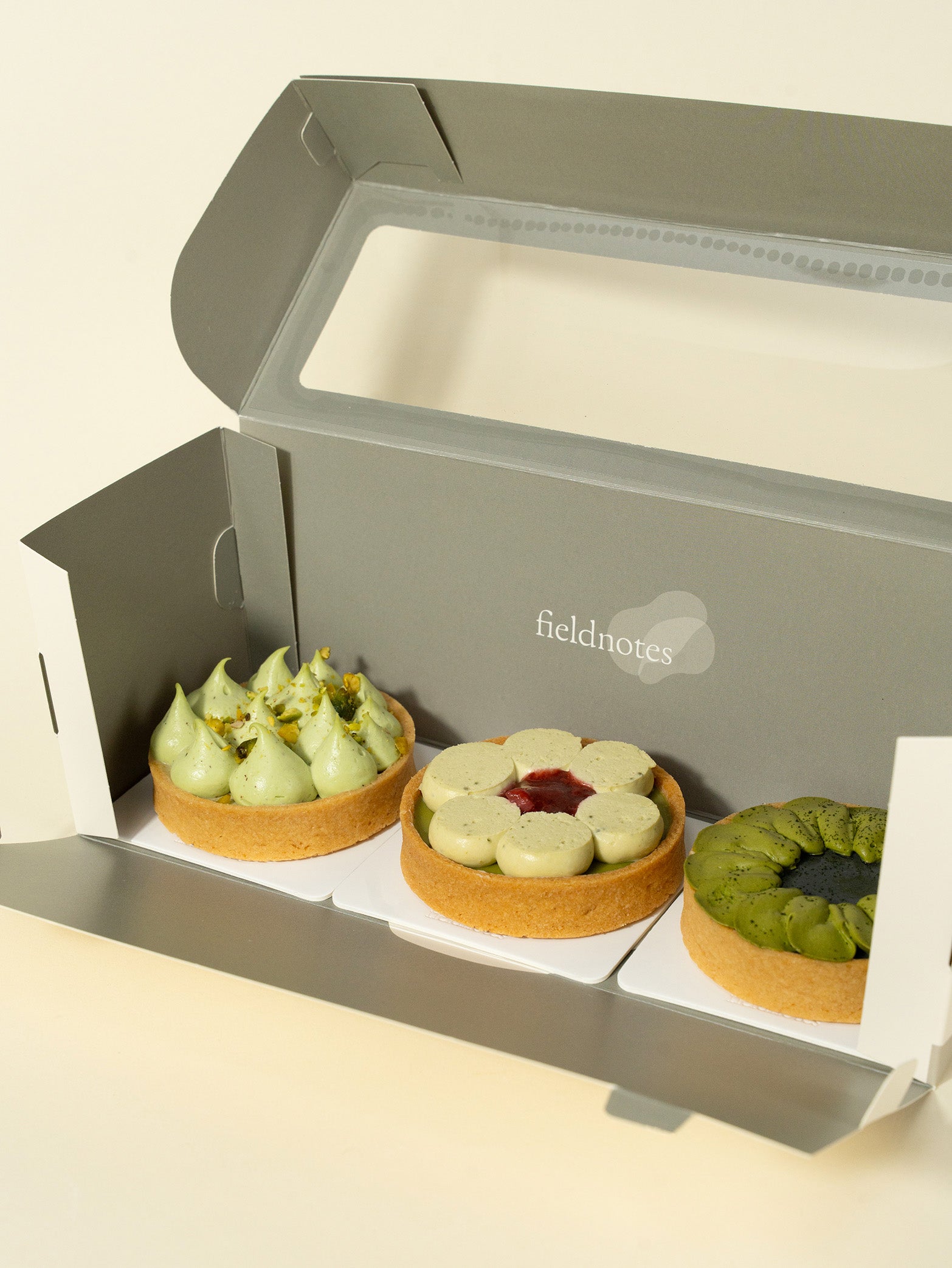 A box of assorted tarts with pistachio, strawberry, and matcha flavors, for tarts order online in Singapore