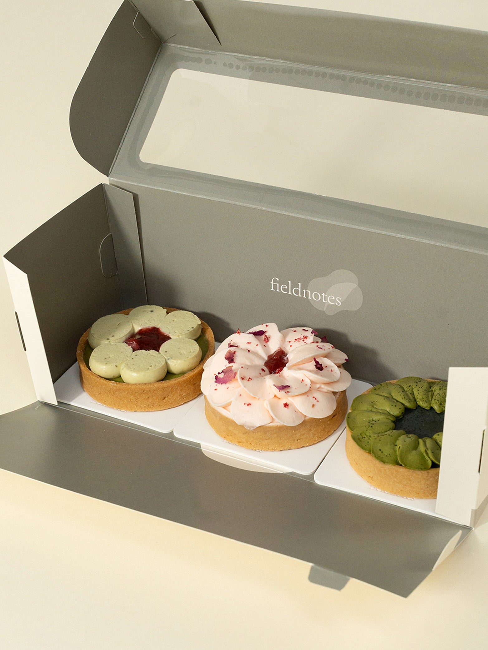 A box of three assorted tarts with a variety of fillings and toppings, including matcha green tea, strawberry, and rose flavors for online order for delivery in Singapore