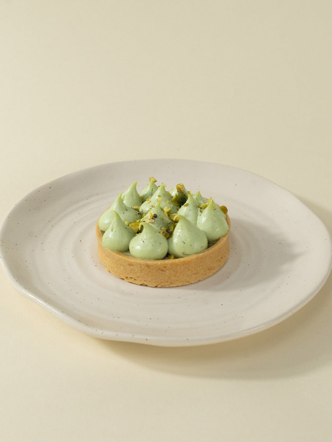 A single Sicilian Pistachio Tart  topped with pistachio praline and pistachio cremeux for tarts order online in Singapore