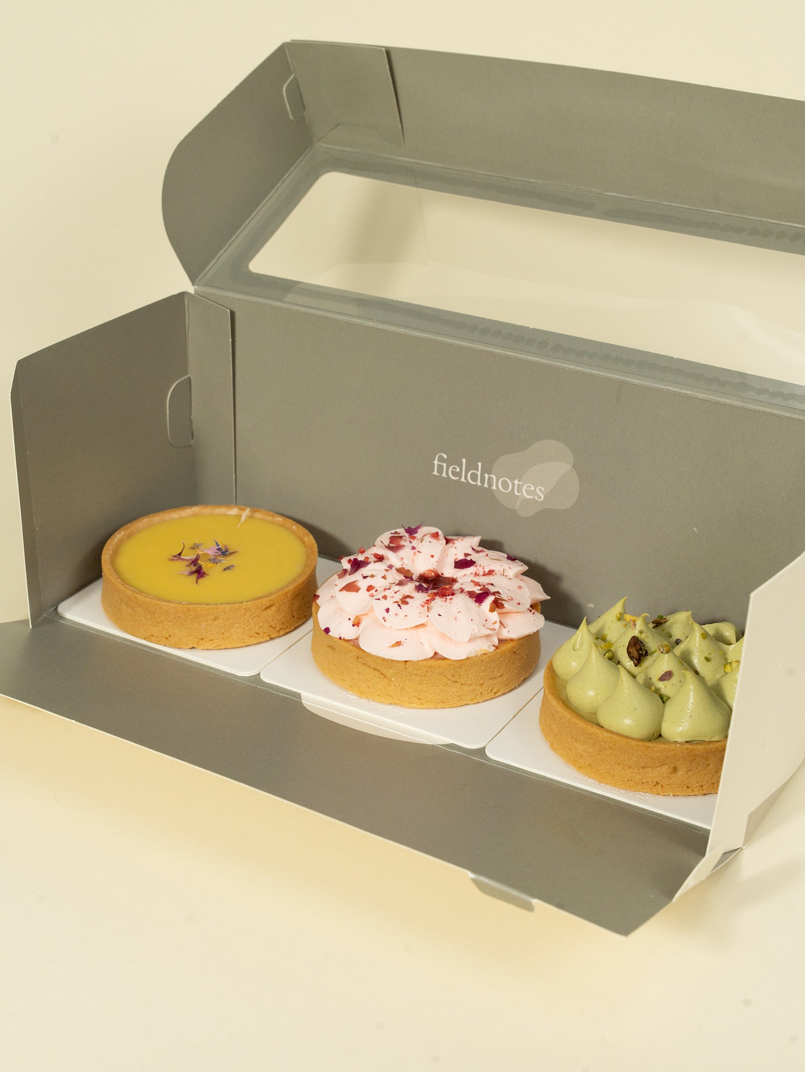 A box of three tarts - strawberry rose, white chocolate passionfruit, and pistachio tart for online order in Singapore