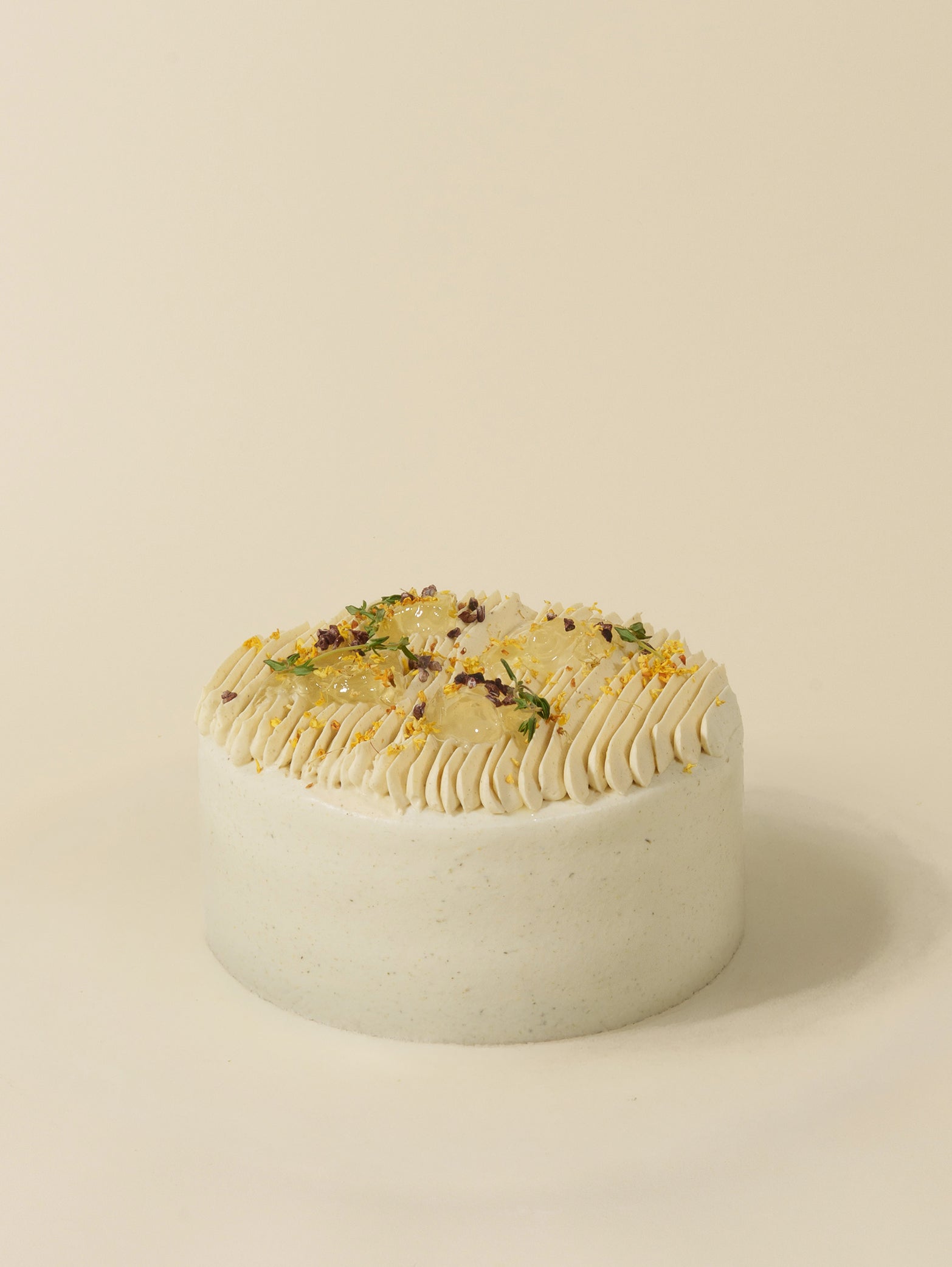 The fieldnotes Chrysanthemum Bloom is a round, white-frosted birthday cake or tart with cream swirls, flower petals, and sprinkles.