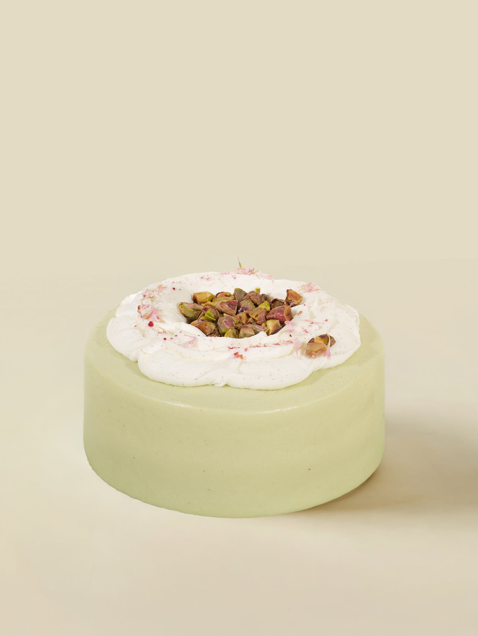 The Pistachio Praline birthday cake by fieldnotes features smooth green icing, whipped cream, and pistachios—perfect for any celebration.