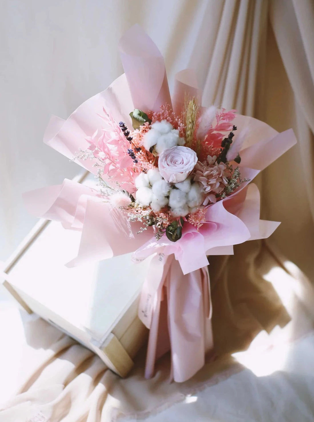 A bouquet of preserved roses and dried flowers arranged in pink shades with a rustic mix, available for online order in Singapore