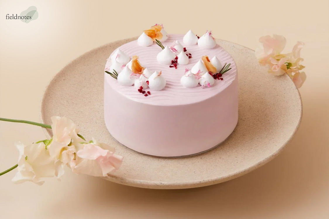 A beautifully decorated light pink holiday cake