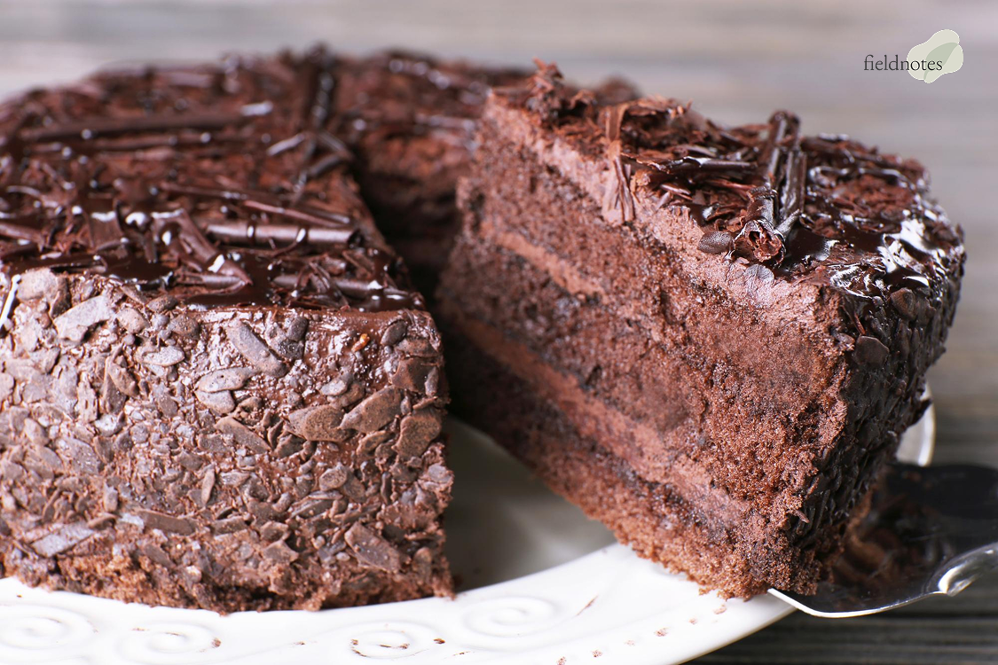 Slicing a rich chocolate cake for a wedding ritual.