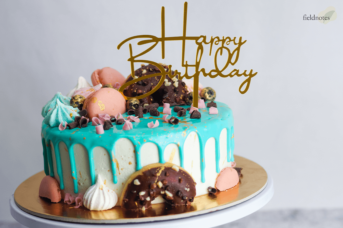 A brightly decorated birthday cake with a Happy Birthday topper