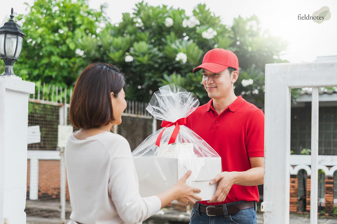 Fieldnotes courier delivering a fresh cake order to a customer.