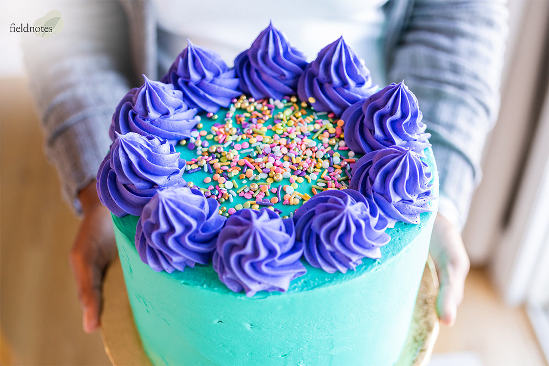 Stable purple frosting swirls on a teal buttercream cake.