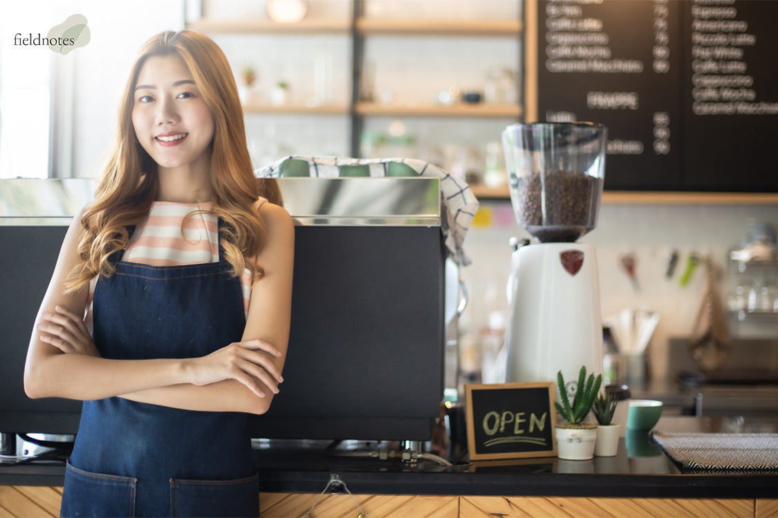 Woman standing next to coffee machine