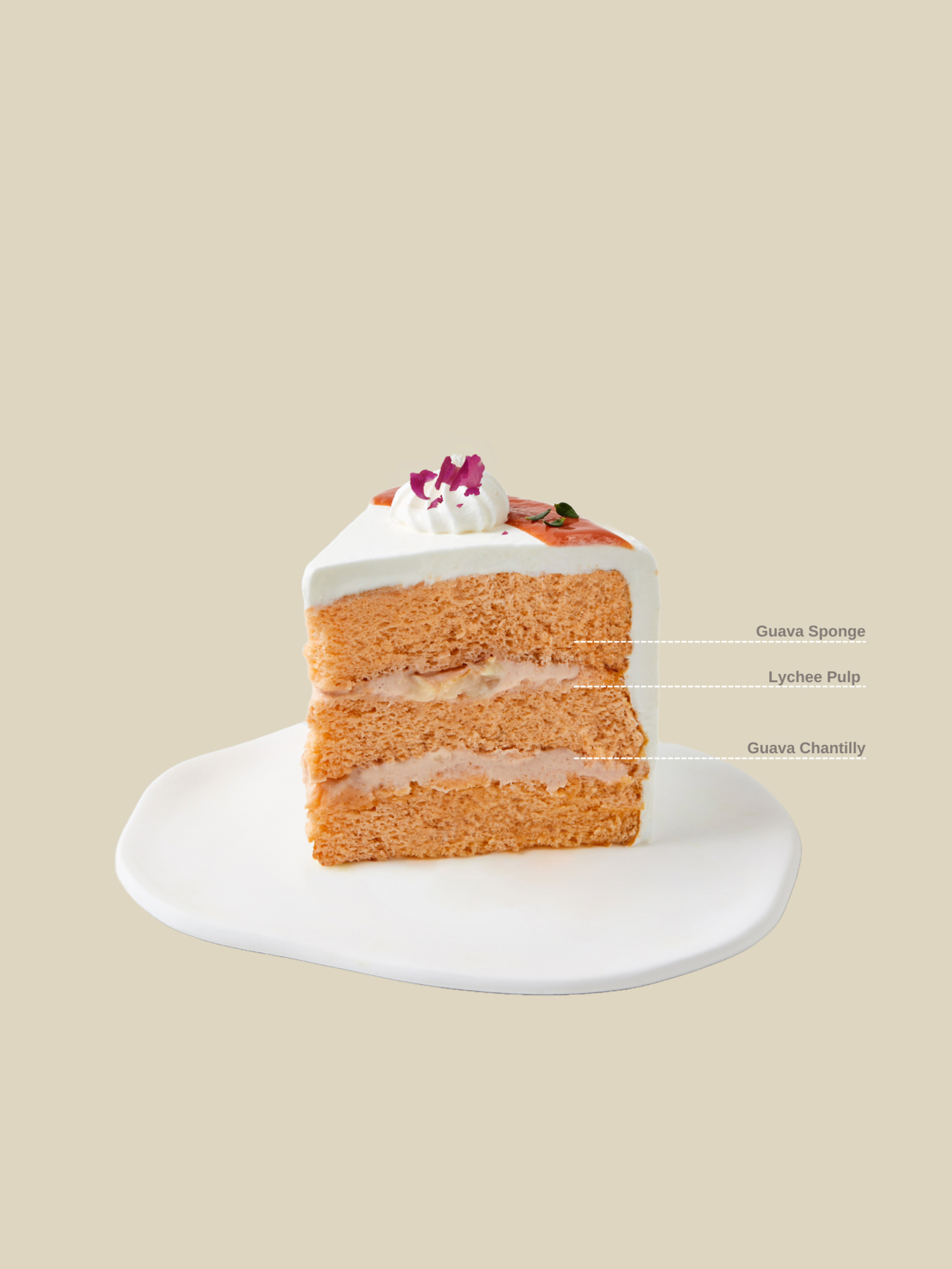 A slice of fieldnotes Guava Lychee birthday cake, layered like a tart, sits on a white plate, topped with guava cream and an edible flower.