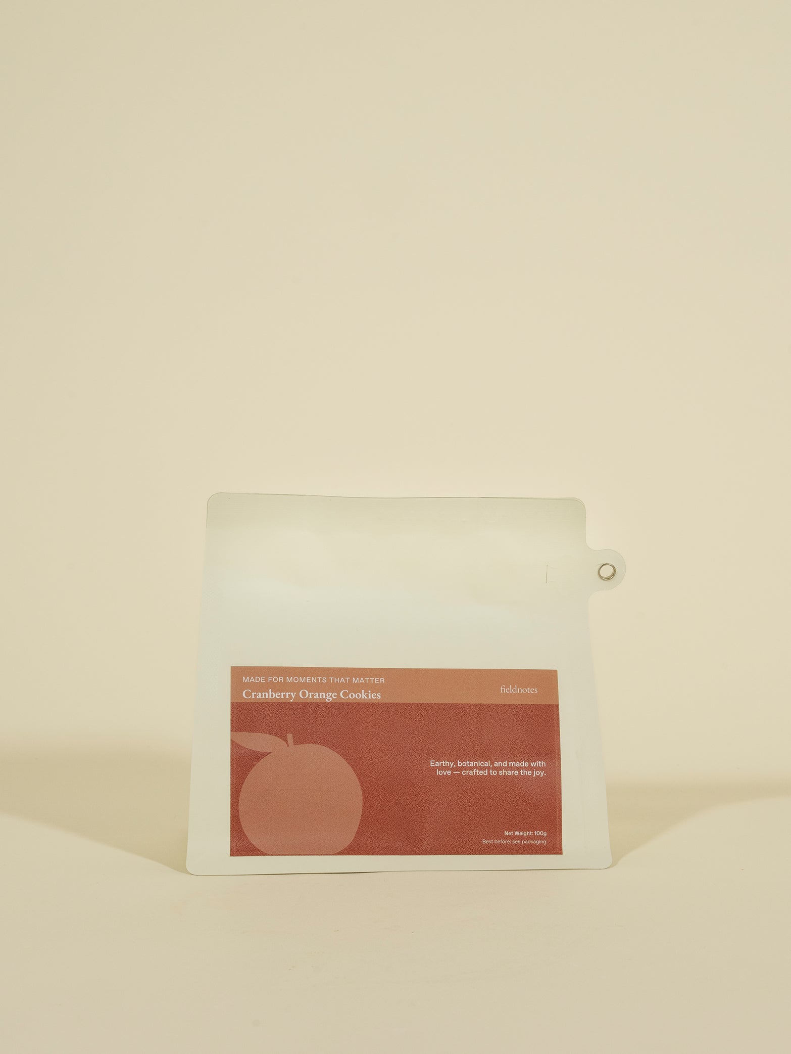 A white pouch with a red "fieldnotes Burnt Butter Orange Cookies (Pouch)" label stands upright, hinting at tart, birthday cake flavors.