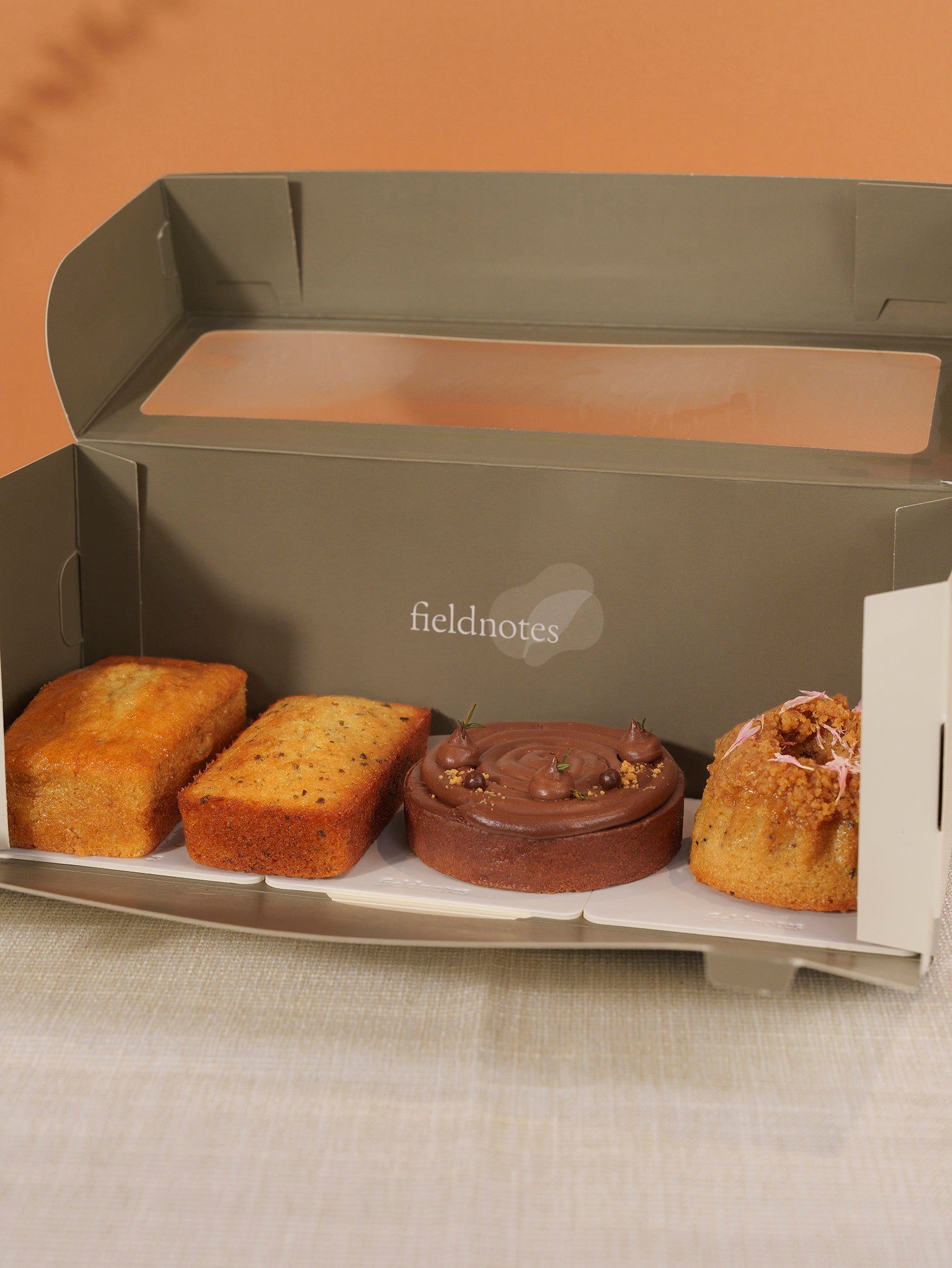 The Quiet Warmth Box has two rectangular cakes, a birthday cake-like crumbly-topped round cake, and a nutty tart—perfect for Dad.