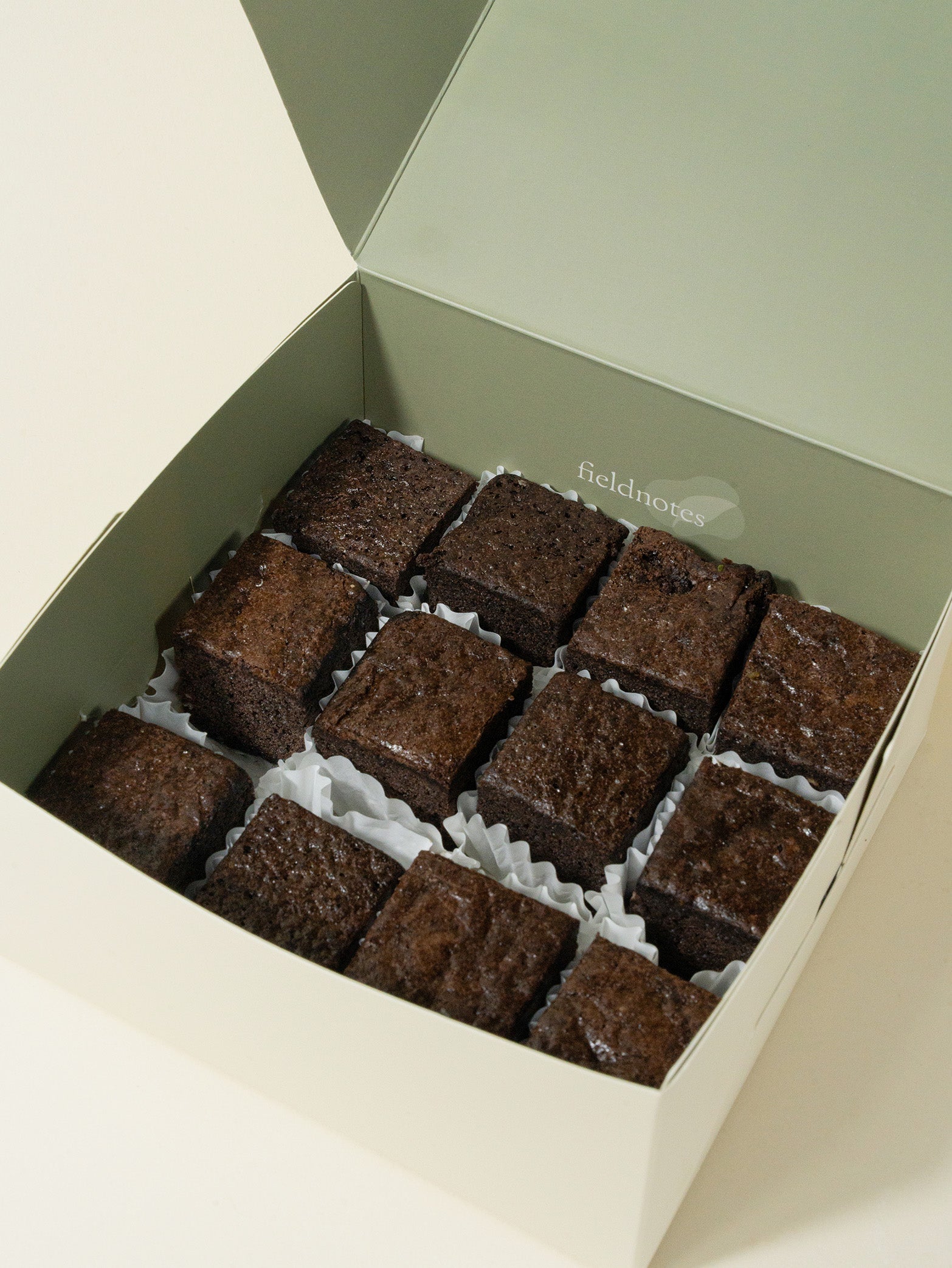 A box of 12 fieldnotes Brownies in white cups, neatly arranged like a birthday cake or tart—perfect for afternoon tea.