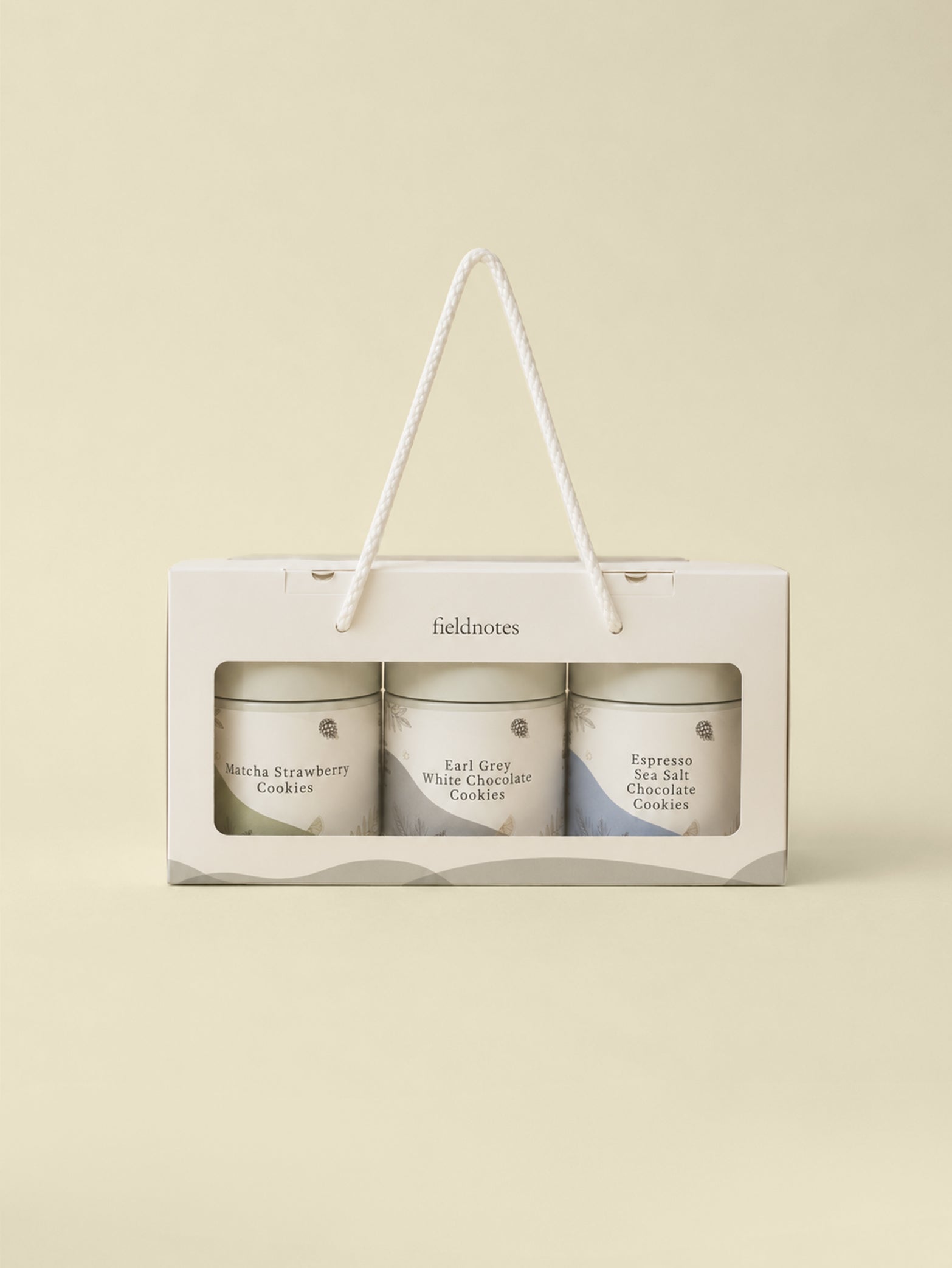 The Days of Wonder Assorted Cookies Set by fieldnotes comes in a cream gift box with rope handle, perfect for pairing with birthday cake or tart. Includes three jars of handcrafted cookies—Matcha Strawberry, Earl Grey White Chocolate, and Espresso Chocolate Salt. Next day delivery available.