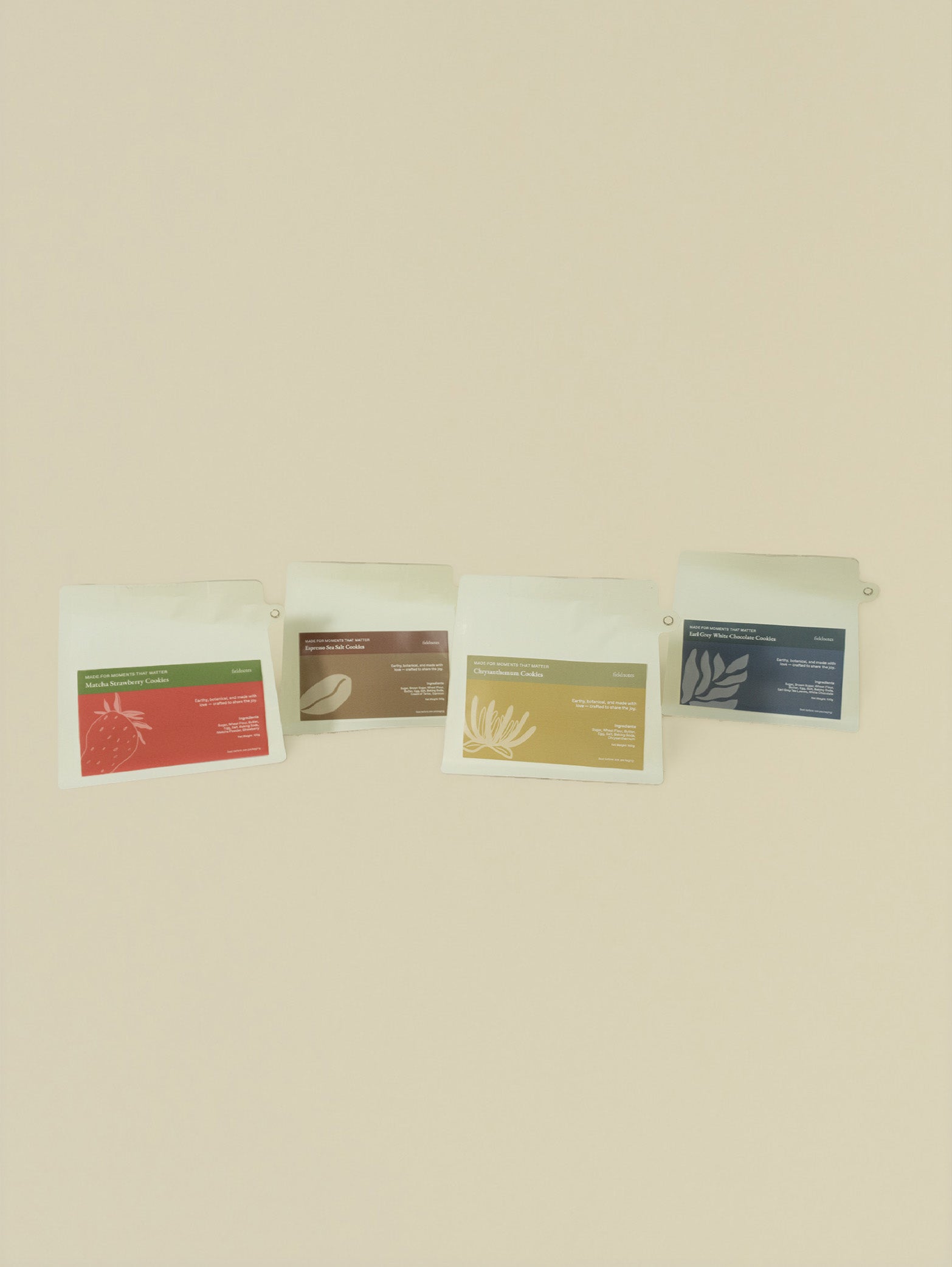 Four Nature's Bliss Cookies pouches, including birthday cake and tart flavors, with colorful labels in a row on beige. Next Day Delivery.
